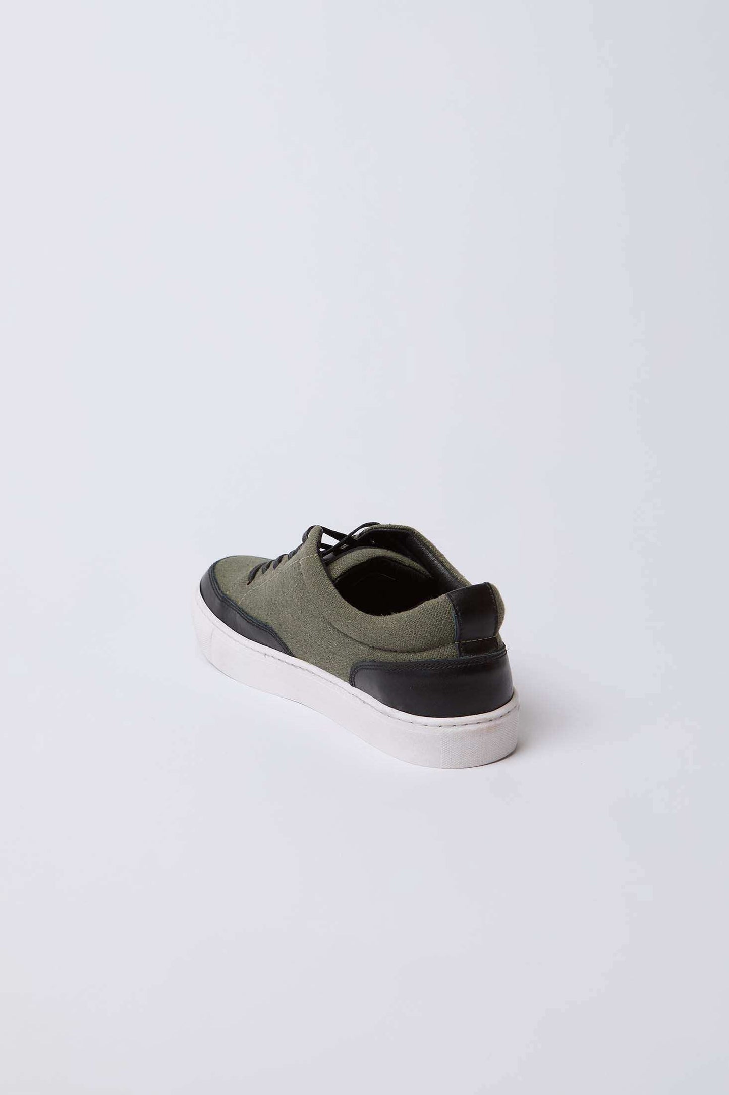 Olive green and black men's casual sneaker with white sole on white background