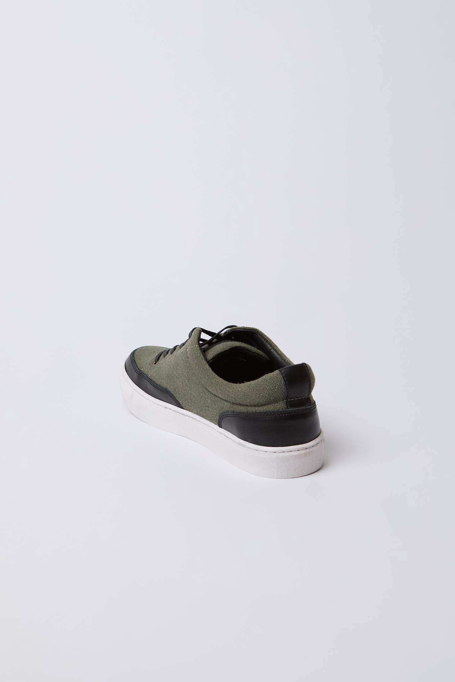 Olive green and black men's casual sneaker with white sole on white background