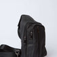 Black leather crossbody bag with multiple zippered pockets and adjustable strap
