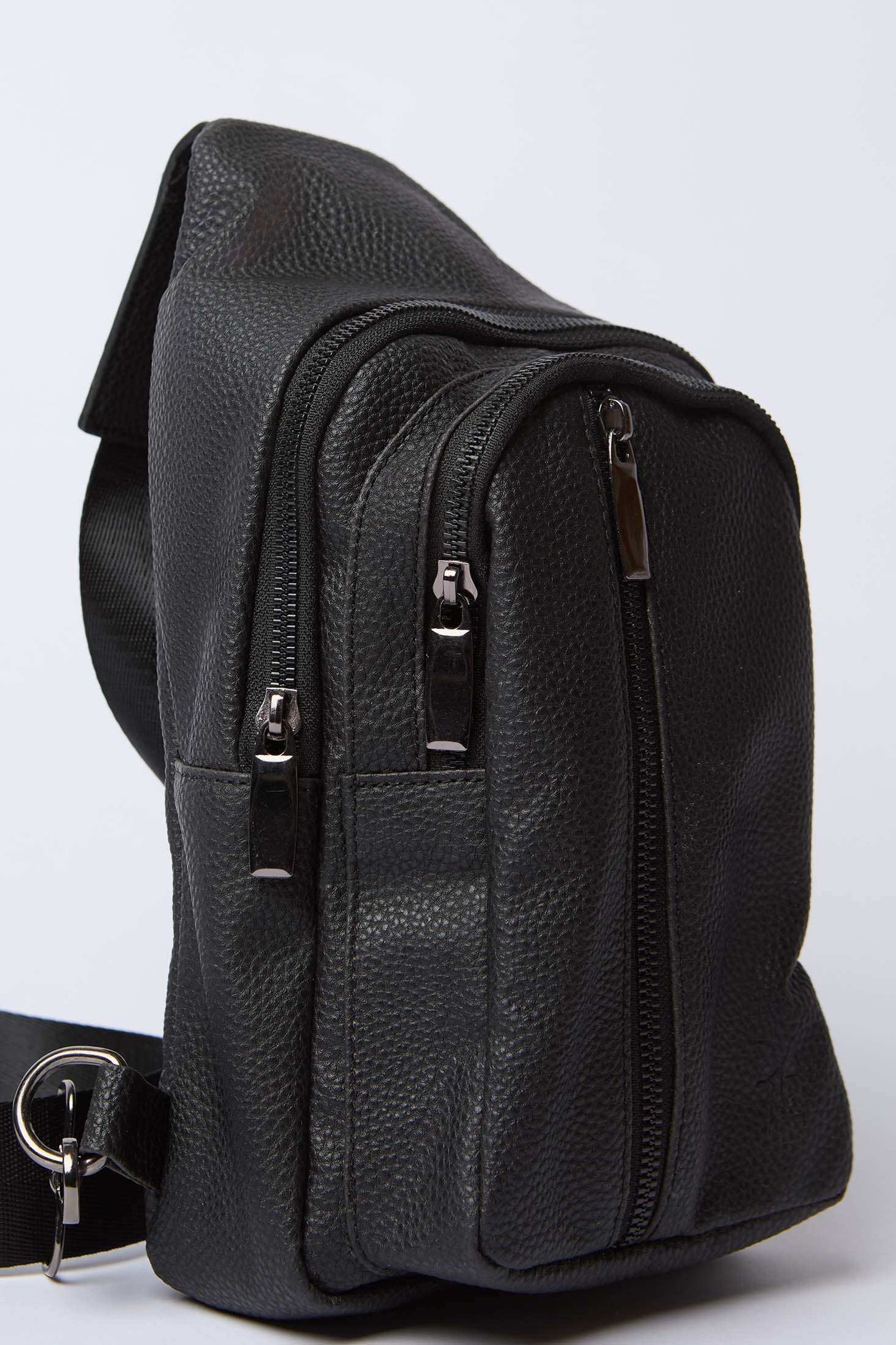 Black textured leather crossbody bag with zippered compartments and adjustable strap