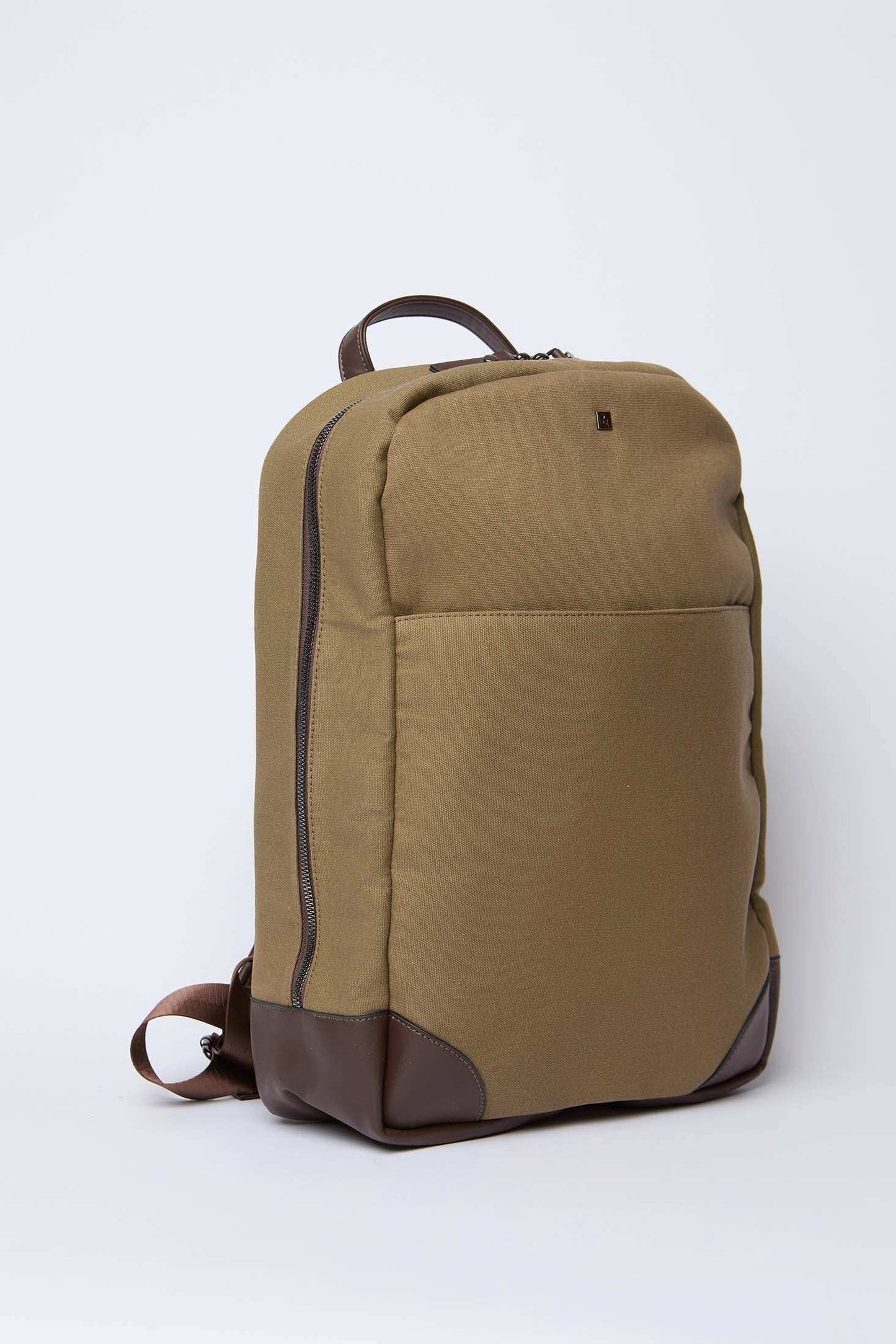 Khaki canvas backpack with brown leather trim and front pocket on white background