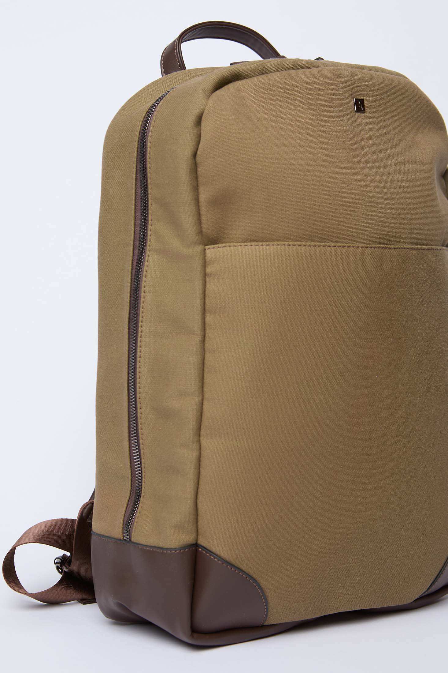 Khaki canvas backpack with brown leather accents and front pocket, side zipper detail
