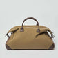 Olive green duffel bag with brown leather handles and accents on white background