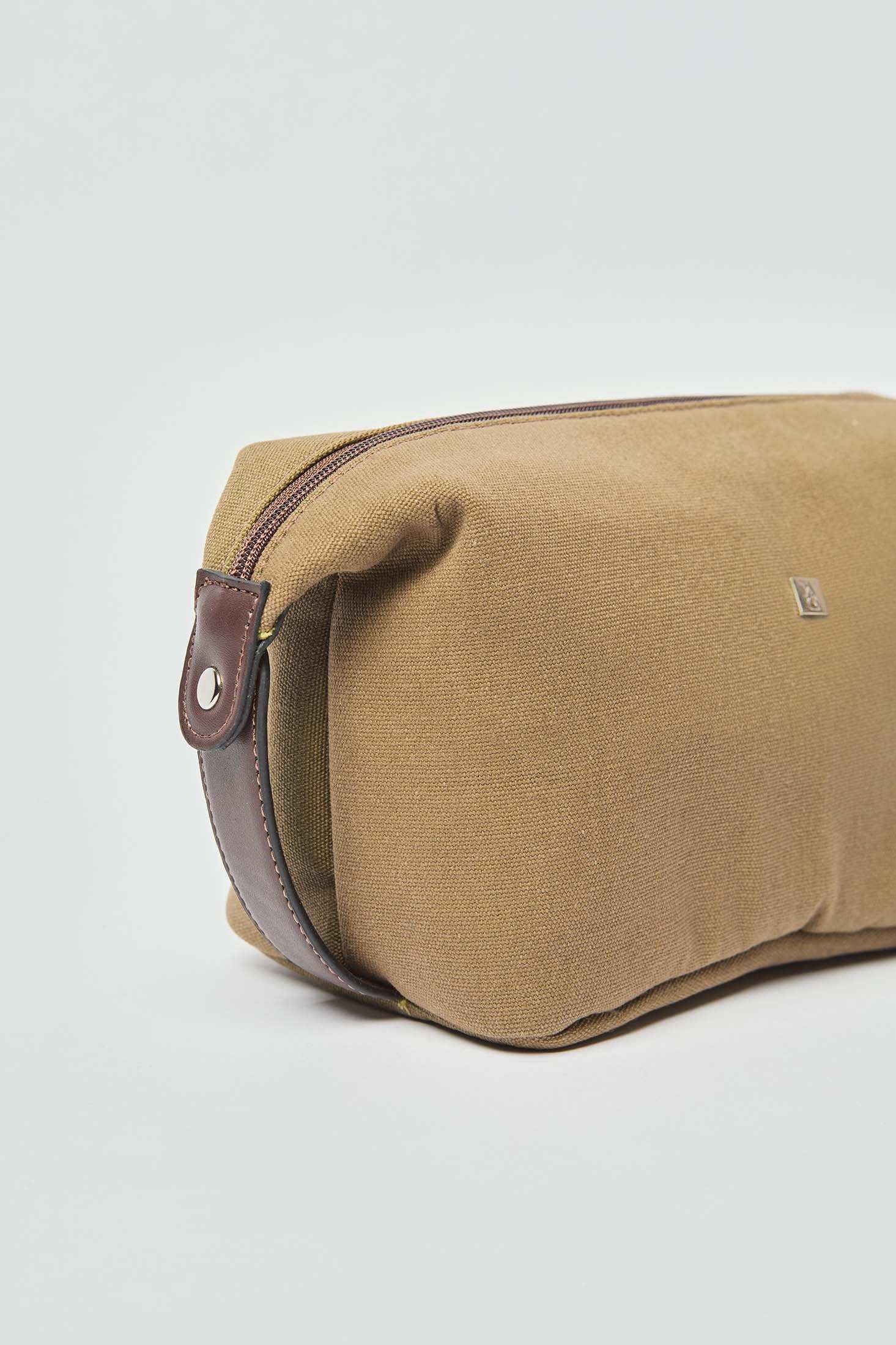 Brown canvas toiletry bag with leather trim and zipper, men's travel accessory.