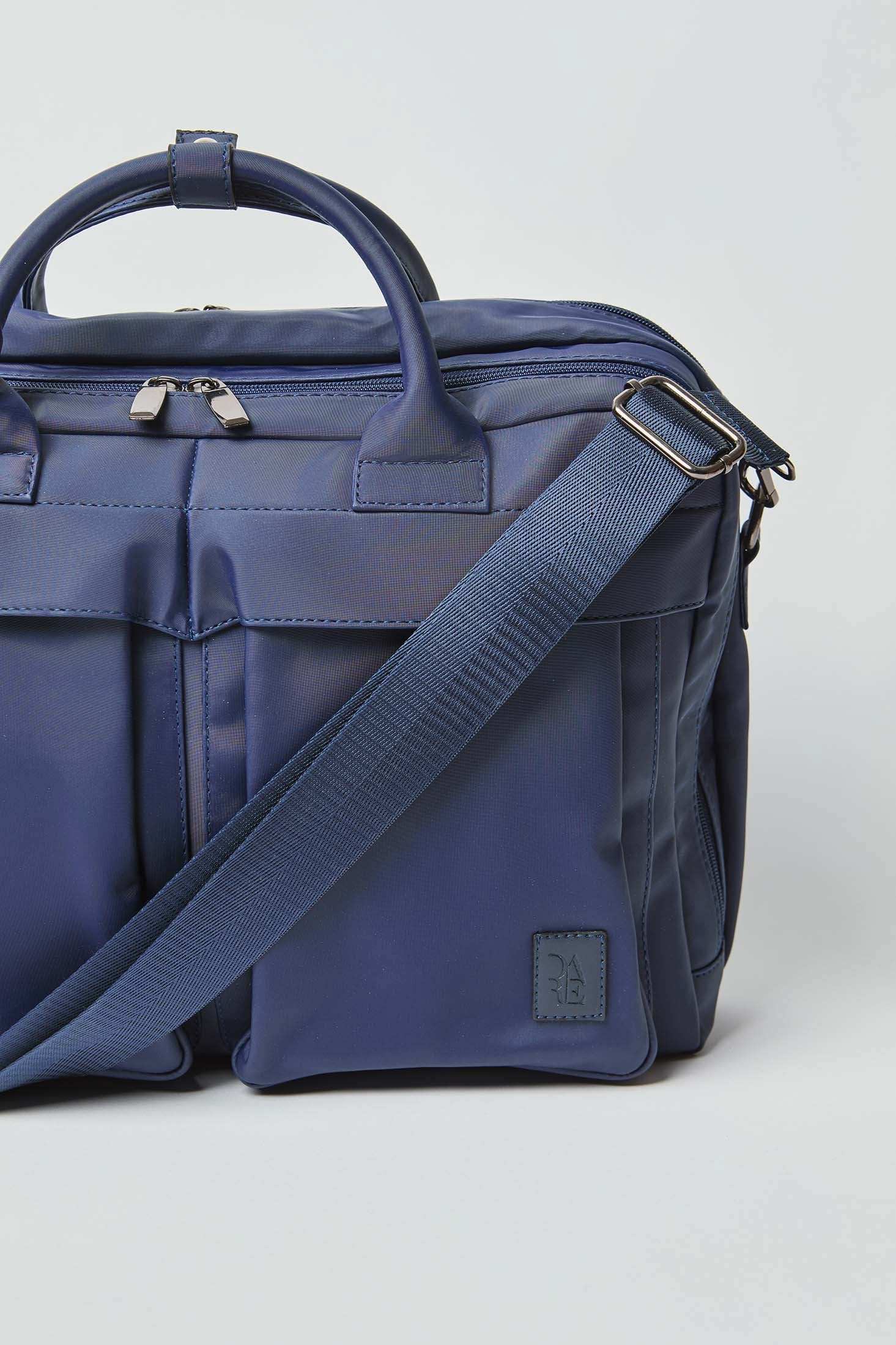 Navy blue nylon crossbody bag with double handles, front pockets, and adjustable strap