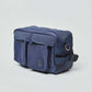 Navy blue rectangular crossbody bag with front pockets, adjustable strap, and zipper closure