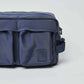 Close-up of a navy blue crossbody bag with front pockets and adjustable strap