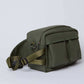 Olive green crossbody bag with front pockets and adjustable strap on a plain background