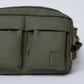 Olive green crossbody bag with dual front pockets and stitched detailing