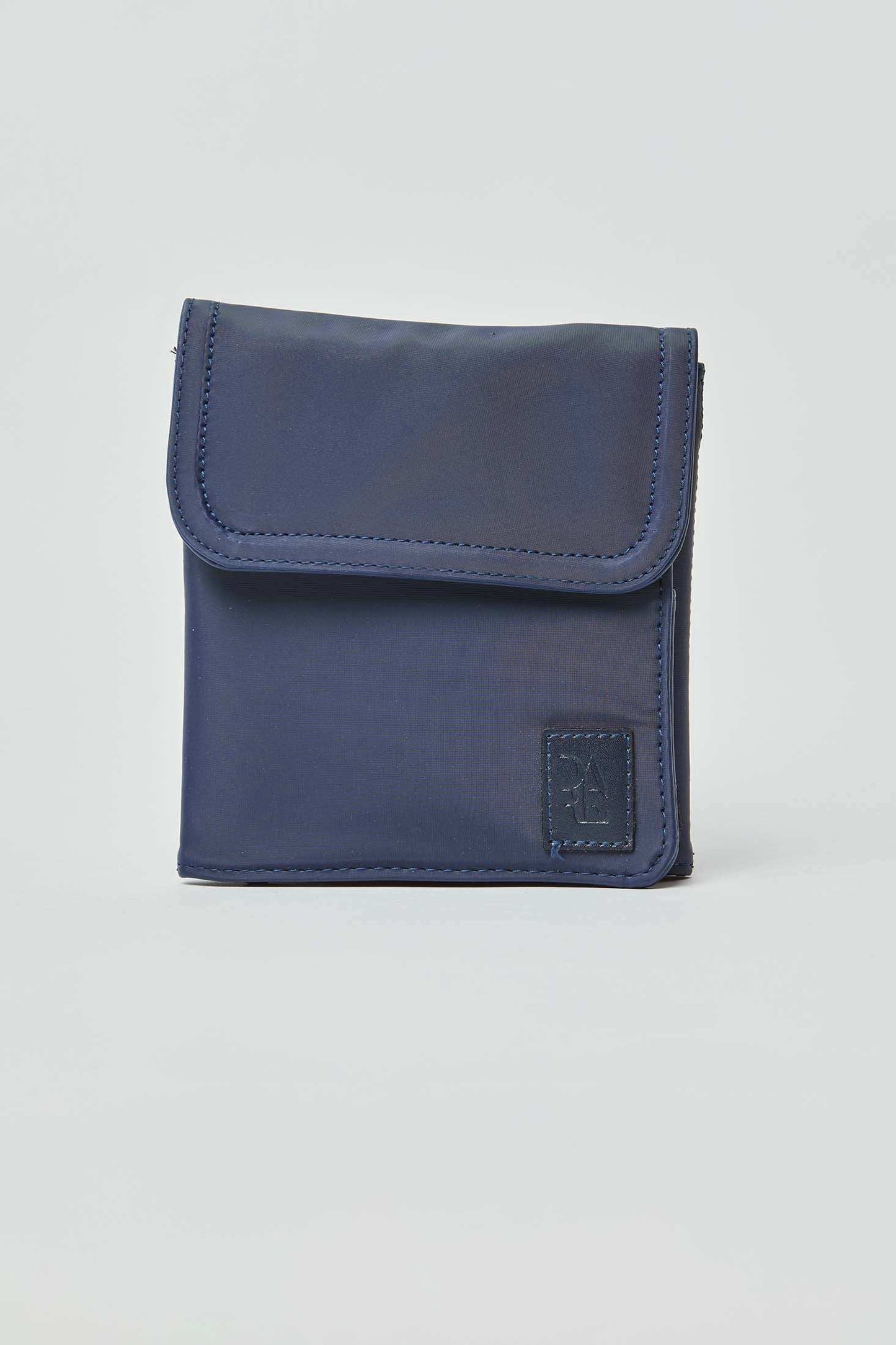 Navy blue compact pouch with front flap and stitched patch, minimal unisex accessory