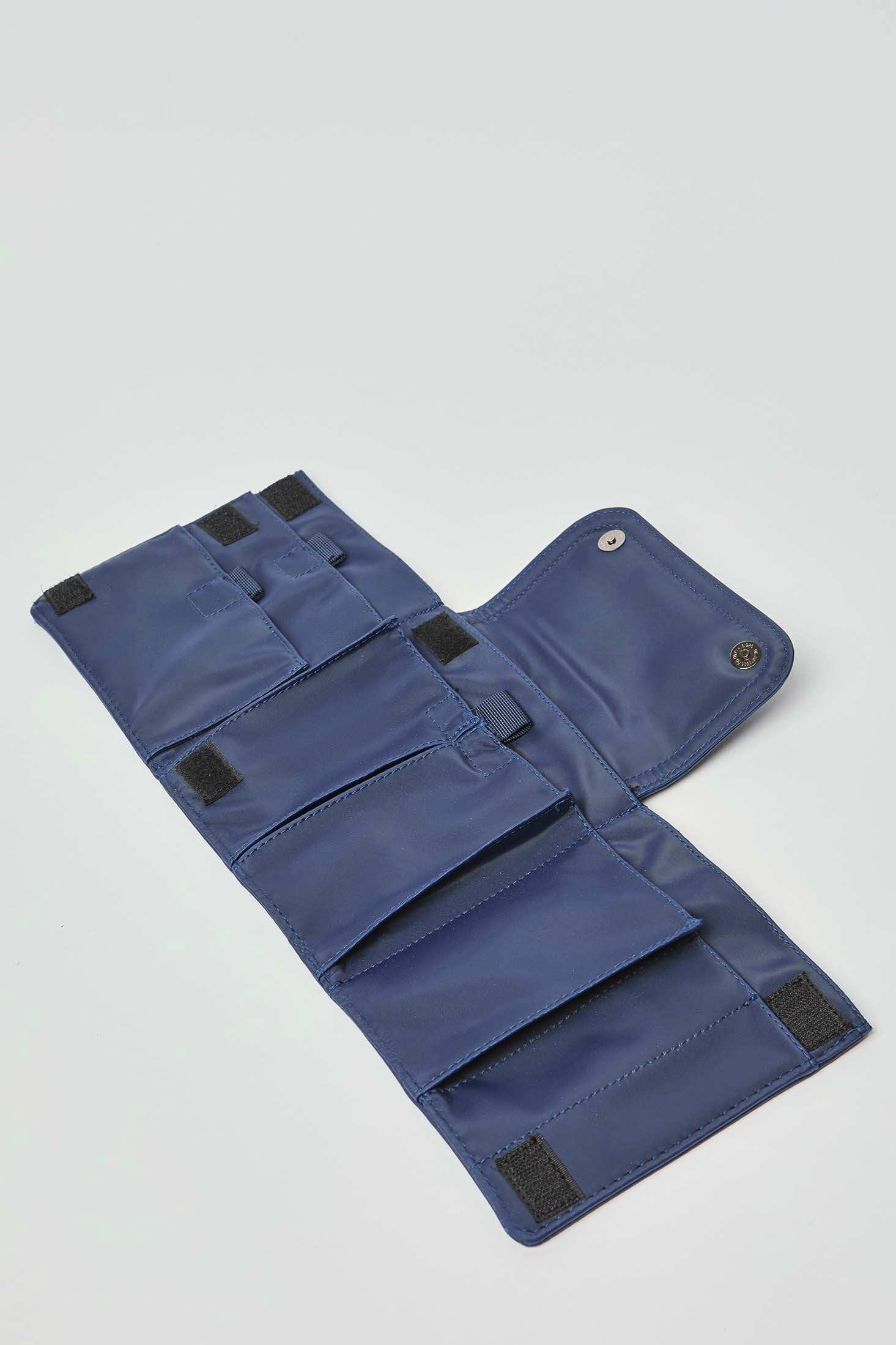 Open blue fabric organizer pouch with multiple pockets and Velcro closures on white background