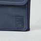 Close-up of navy blue fabric bag with stitched corner and embossed logo patch