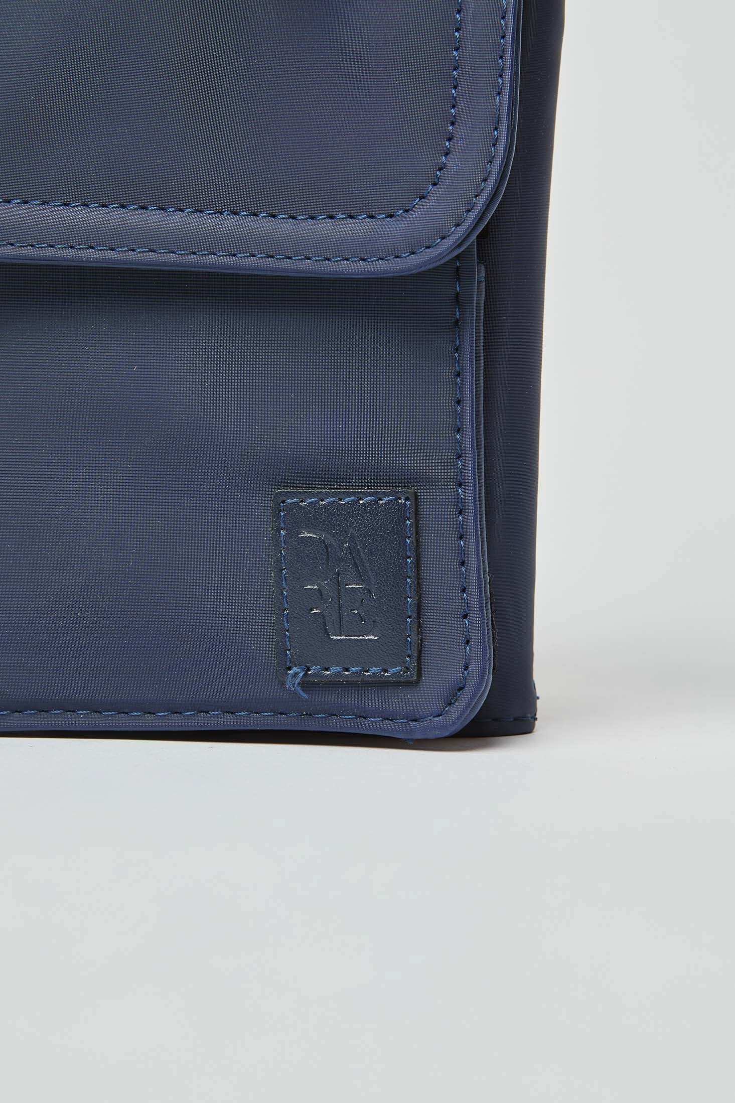 Close-up of navy blue fabric bag with stitched corner and embossed logo patch
