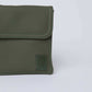 Close-up of olive green leather crossbody bag with flap and stitched edges on light background