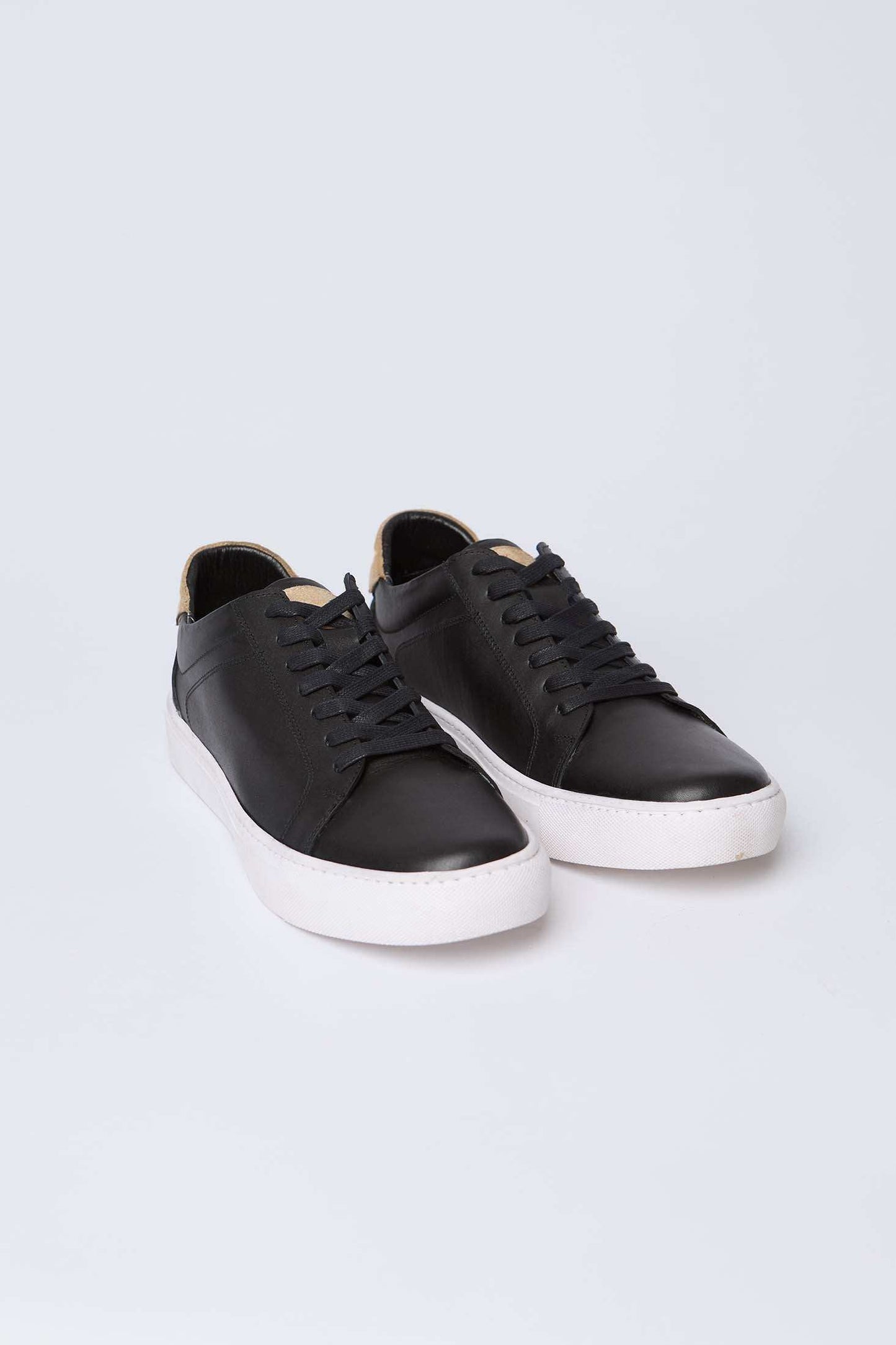 Dalydress men's black leather sneakers with white sole on plain background