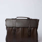 Dalydress dark brown leather men's briefcase with handle and buckle straps on white background