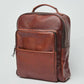 Dalydress brown leather backpack with front pocket and top handle on white background