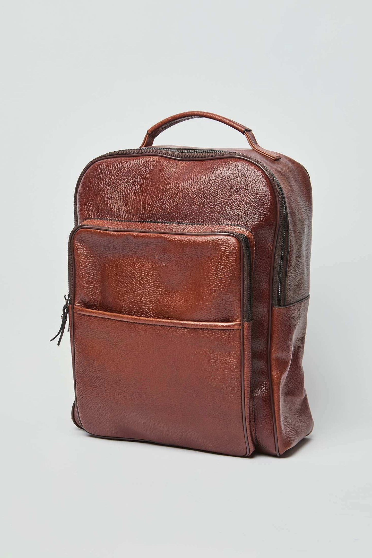Dalydress brown leather backpack with front pocket and top handle on white background