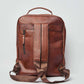 Dalydress brown leather backpack with adjustable straps and front zip pocket on white background