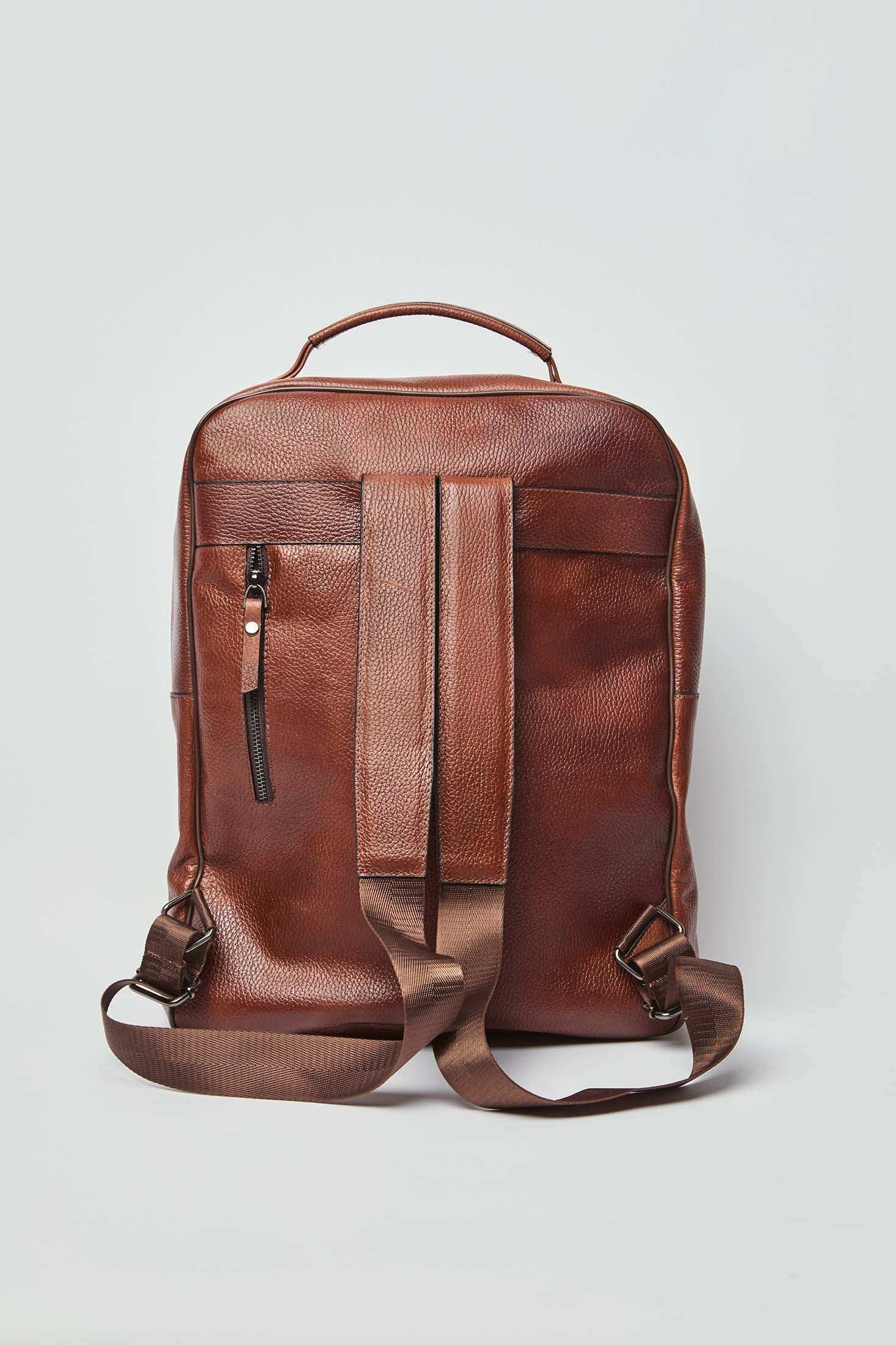 Dalydress brown leather backpack with adjustable straps and front zip pocket on white background