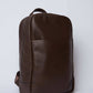 Dalydress brown leather backpack with front pocket, minimalist design on white background