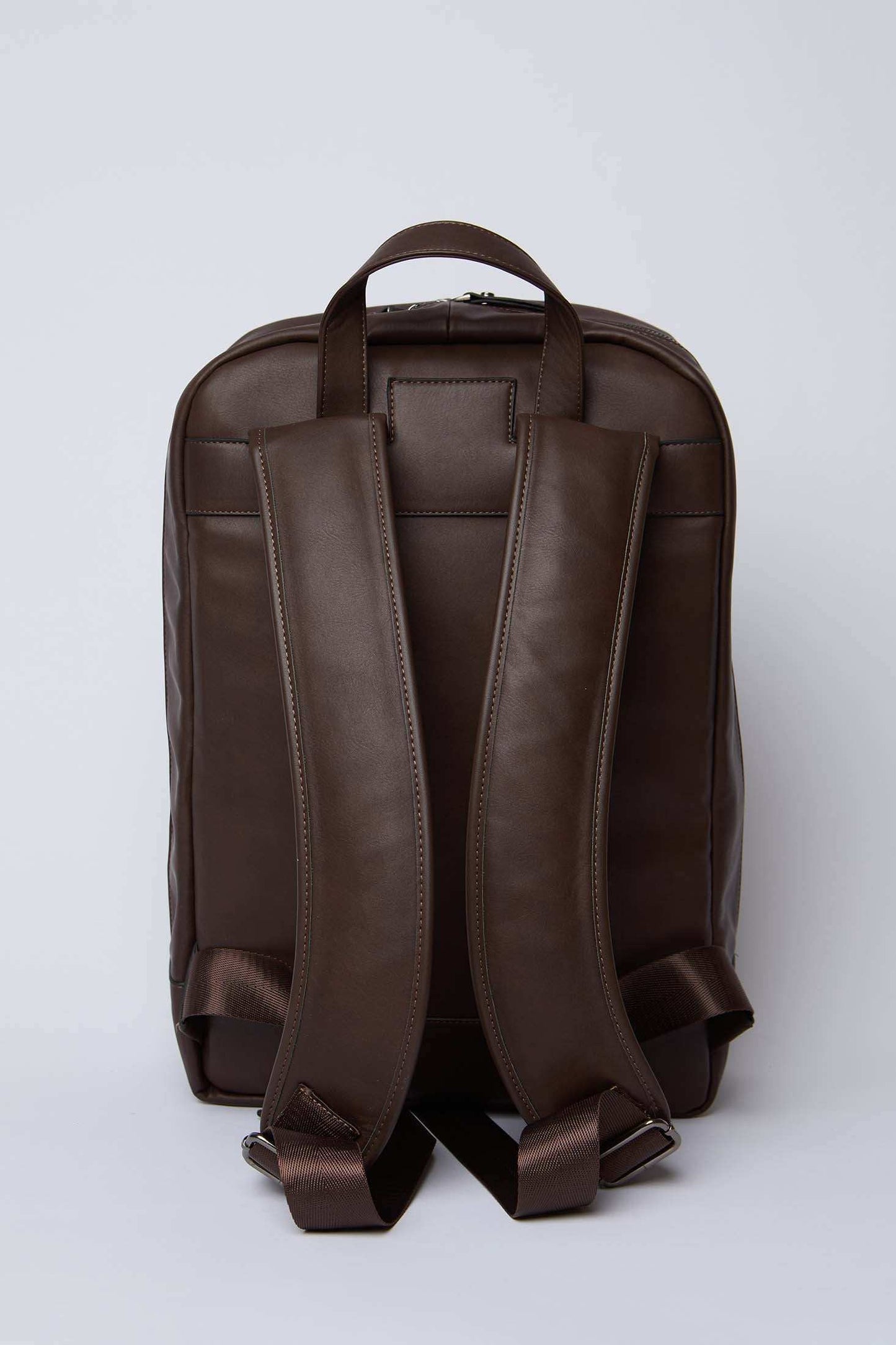 Dalydress brown leather backpack with padded straps, back view, on white background