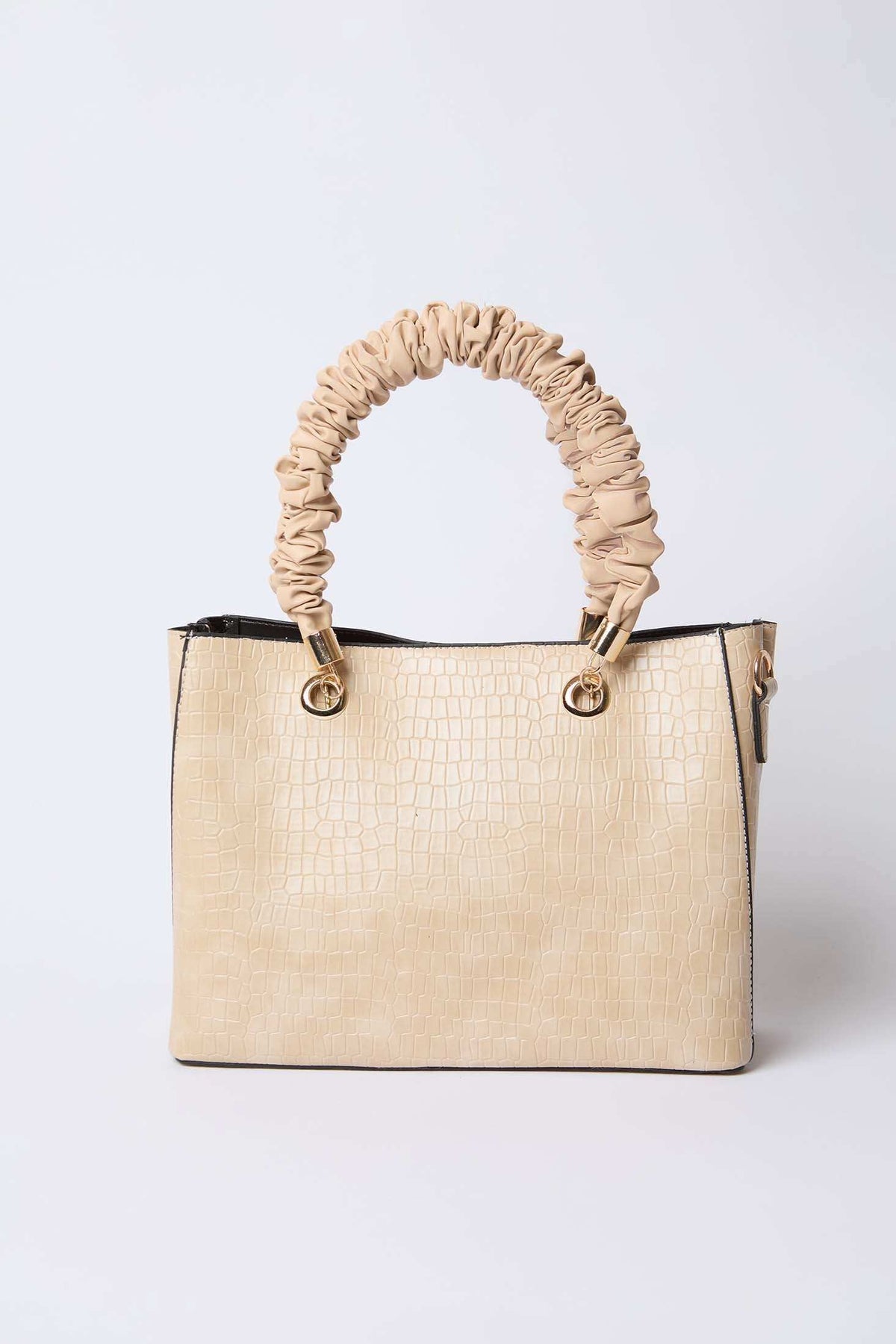 Beige textured handbag with ruched handle and gold hardware on white background