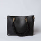 Black faux crocodile leather handbag with gold hardware and ruched handle on white background