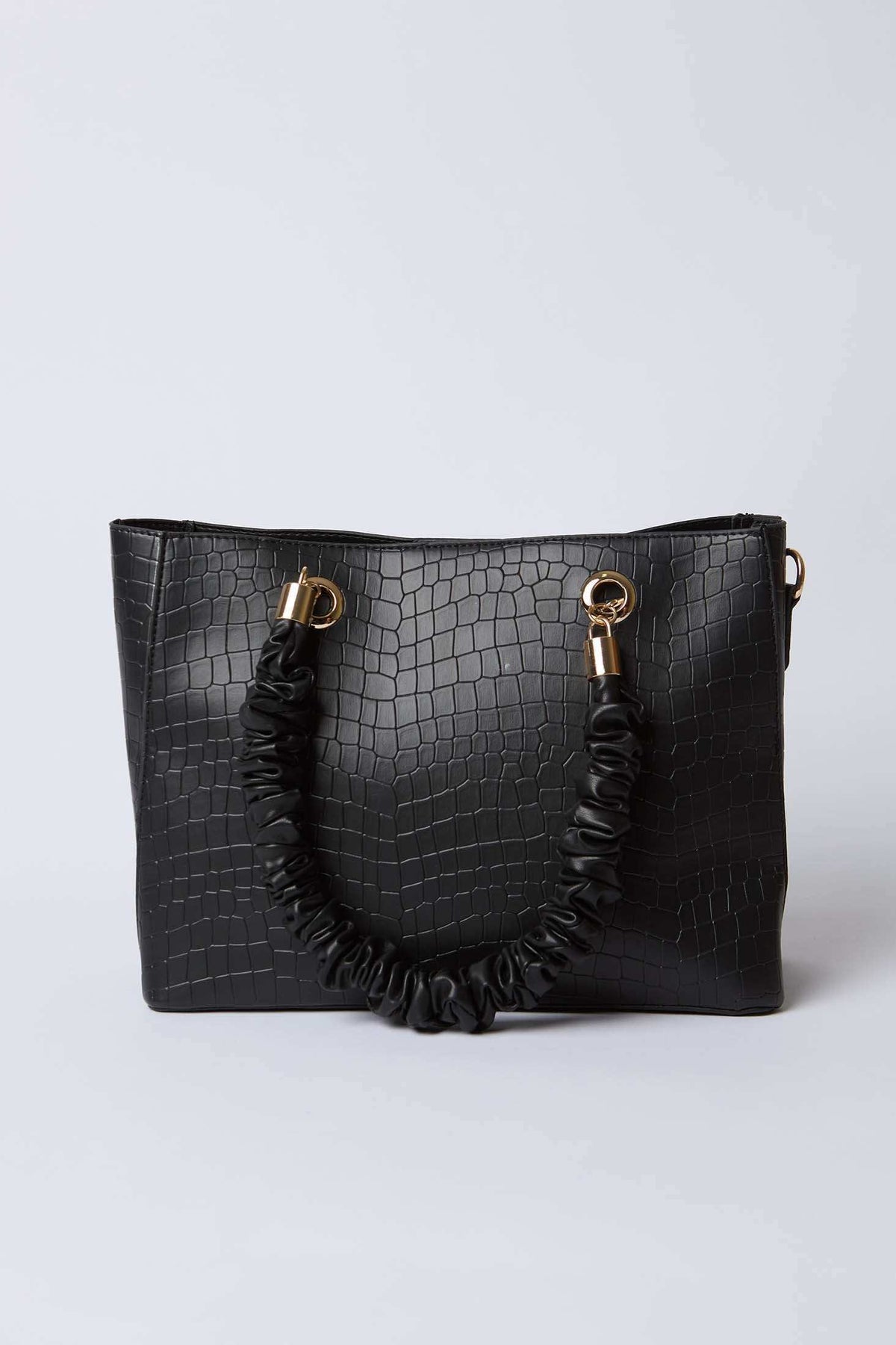 Black faux crocodile handbag with gold-tone rings and ruched handle on a white background
