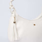 White shoulder bag with gold logo and tassel, elegant women's accessory