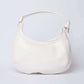 White leather shoulder bag with curved design and adjustable strap on plain background