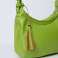 Green women's handbag with top handle and brown tassel keychain, minimalist style