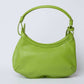 Green leather shoulder bag with single handle on plain background