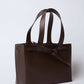 Brown leather tote bag with double handles and minimalist design on white background