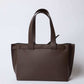 Brown leather tote bag with double handles on a plain white background