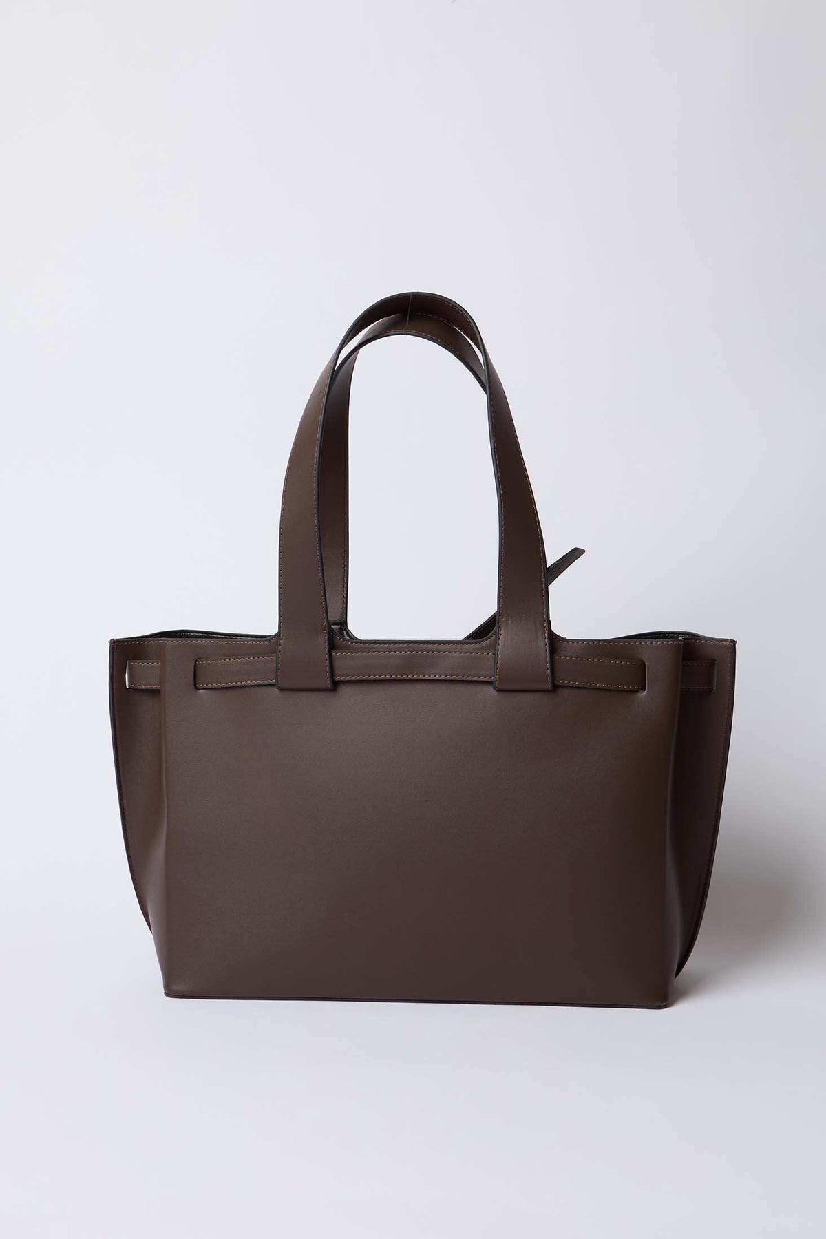 Brown leather tote bag with double handles on a plain white background