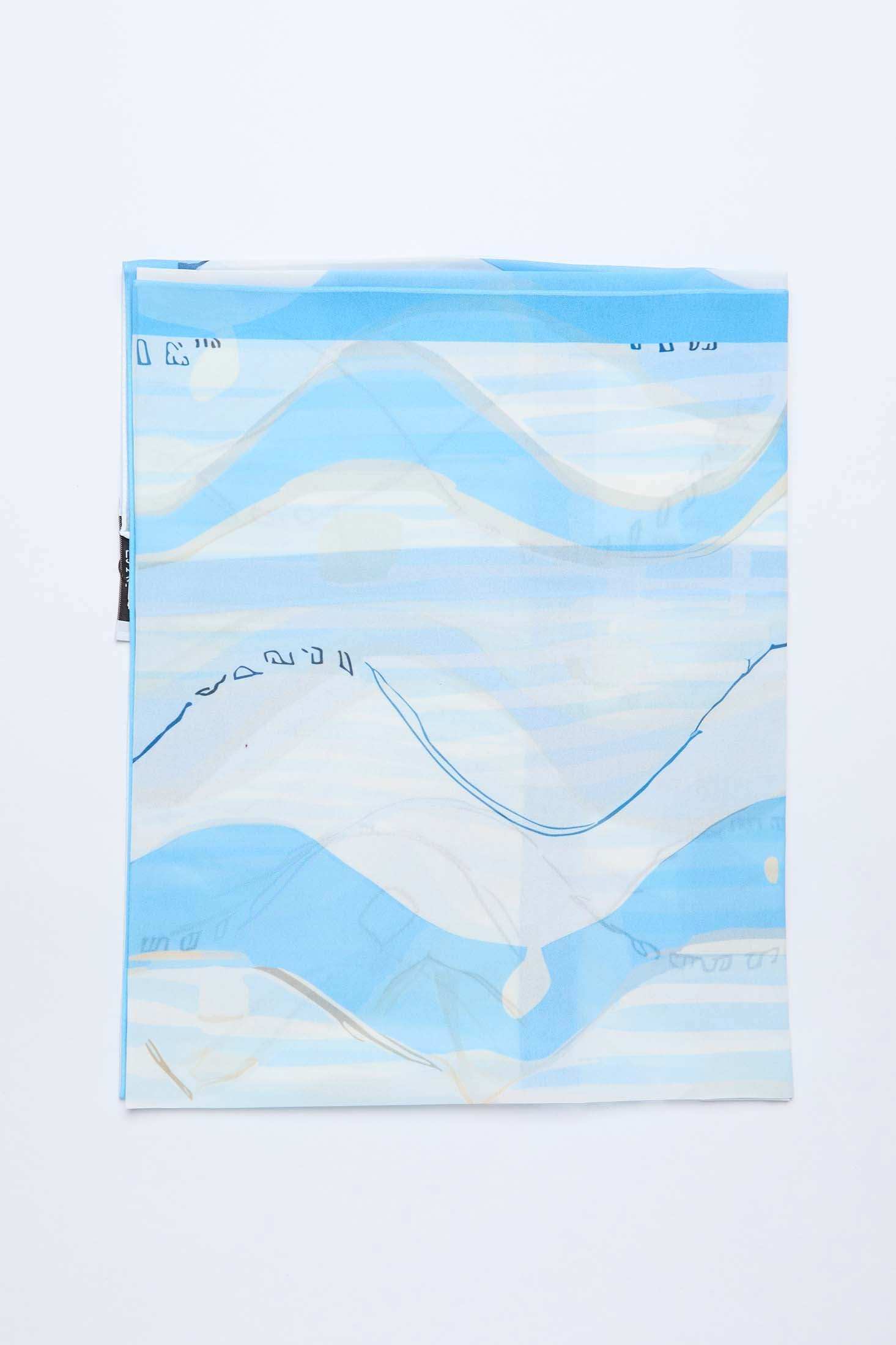 Folded blue and white abstract patterned scarf on white background