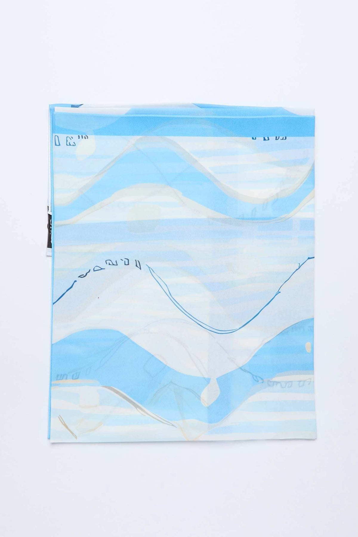 Folded blue and white abstract patterned scarf on white background