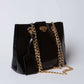Dalydress black leather handbag with gold chain strap and metal clasp on white background