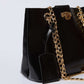 Dalydress black leather handbag with gold chain strap and logo tag on white background