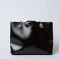Dalydress black leather handbag with gold chain straps on white background
