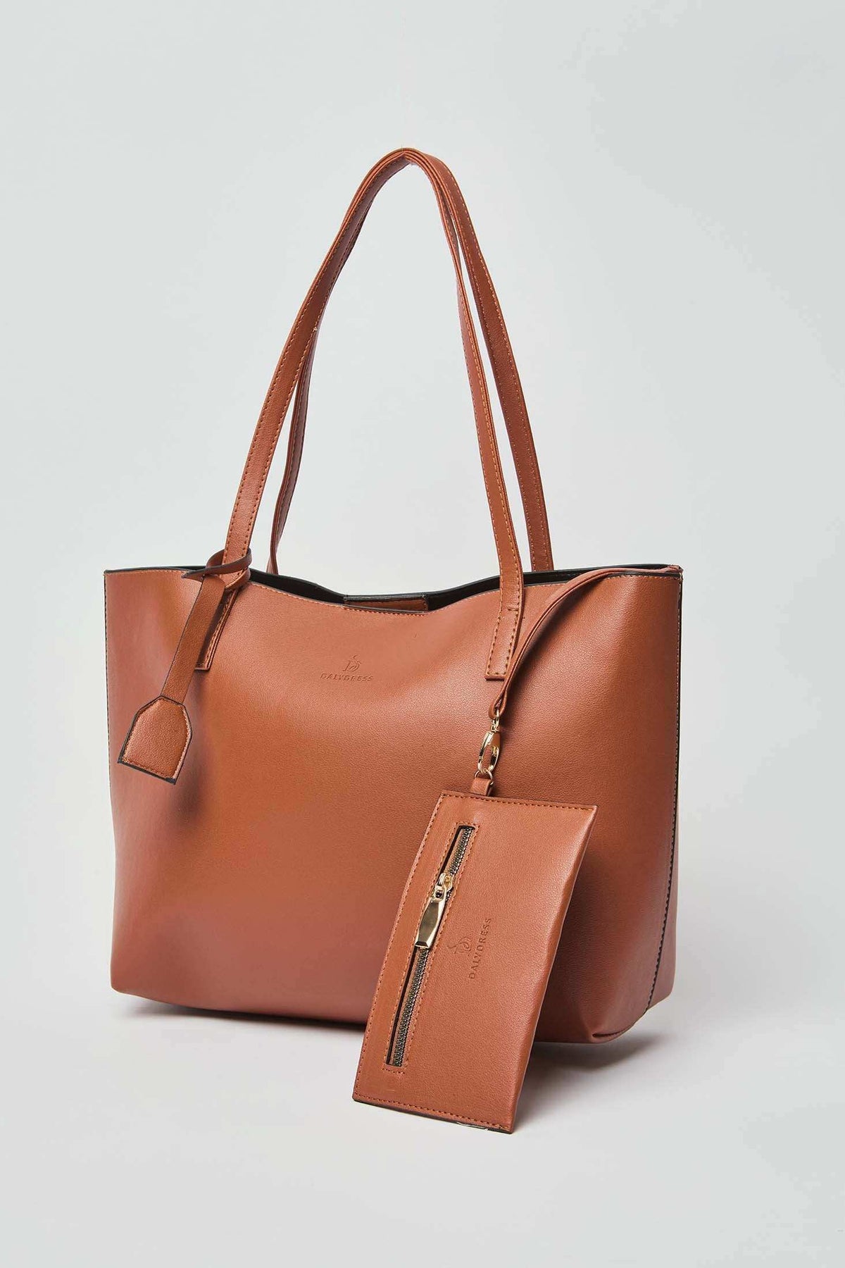 Dalydress brown leather tote bag with matching zippered pouch, minimalist background