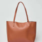Dalydress brown leather tote bag with double handles on a plain background