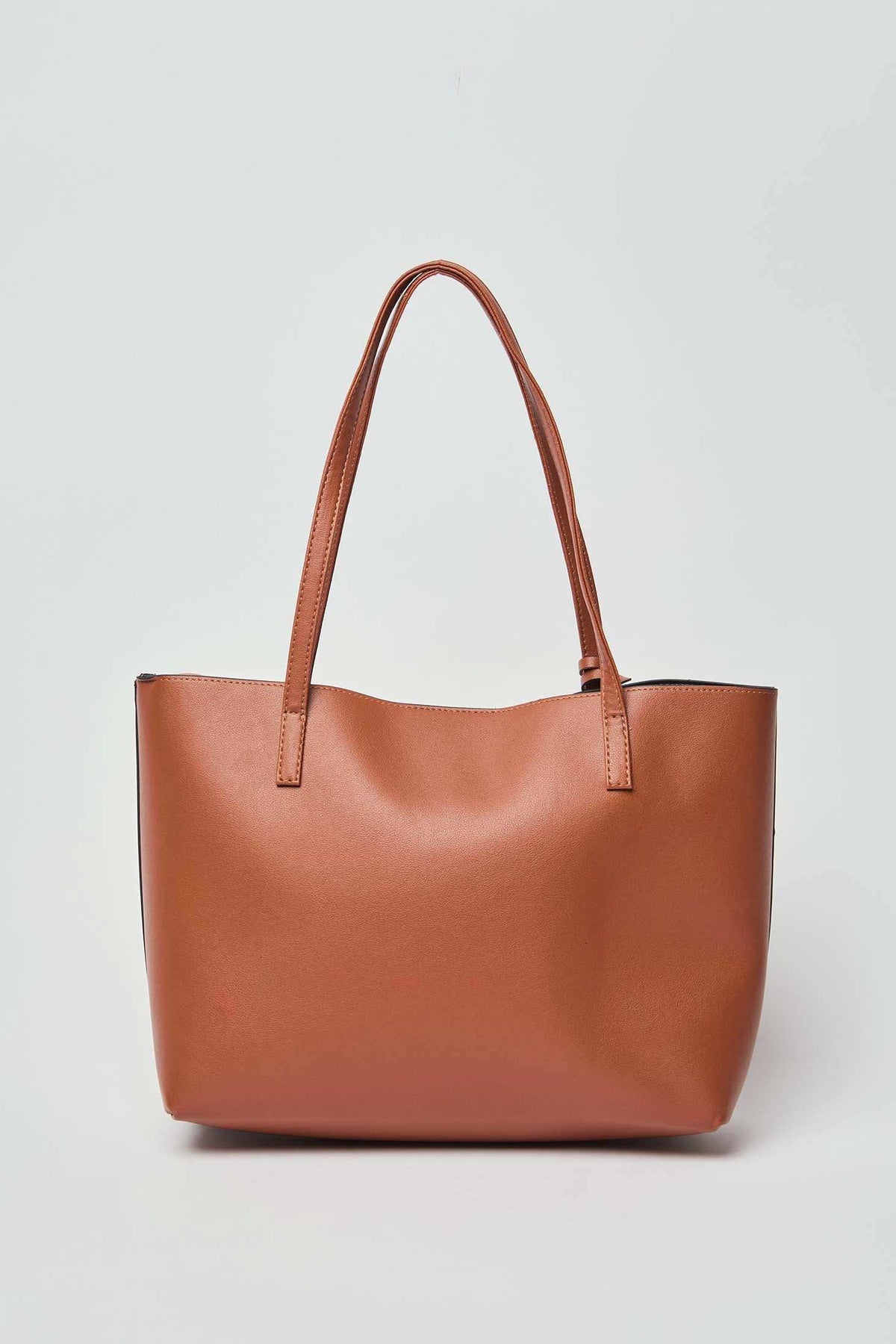 Dalydress brown leather tote bag with double handles on a plain background