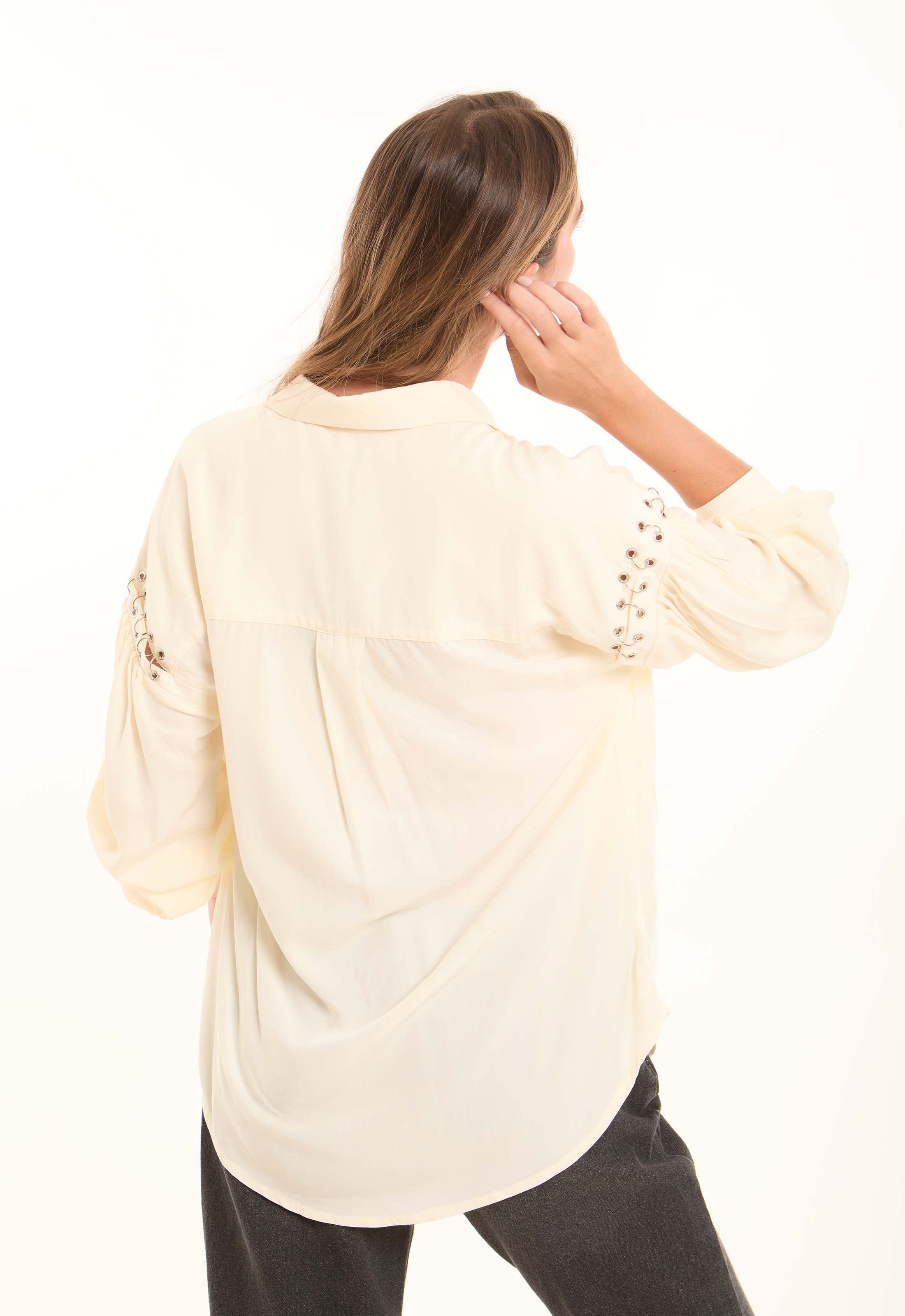 بلوزة ناعمة بقصة واسعة وياقة برباط وتفاصيل رقيقة على الأكمام