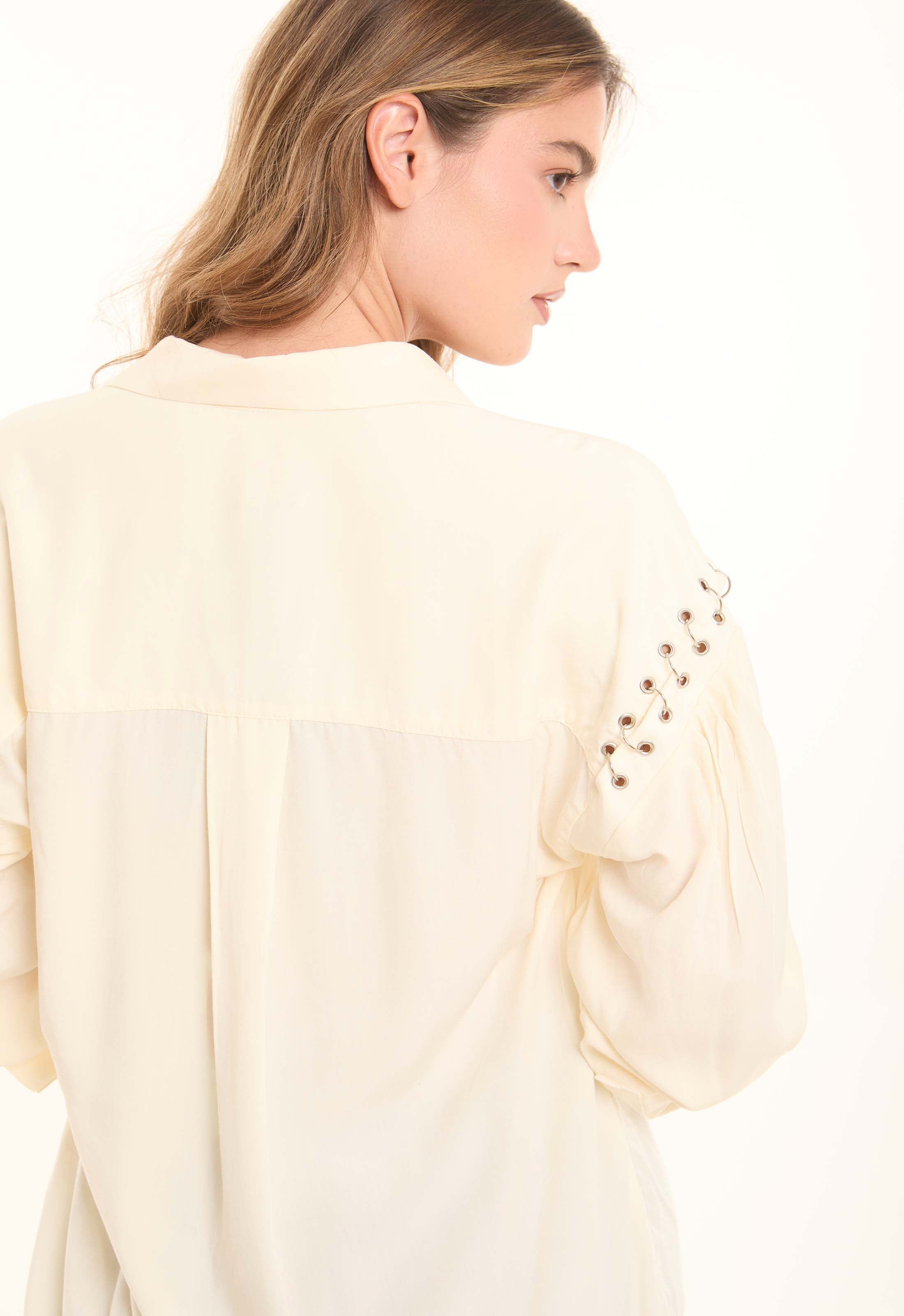 بلوزة ناعمة بقصة واسعة وياقة برباط وتفاصيل رقيقة على الأكمام